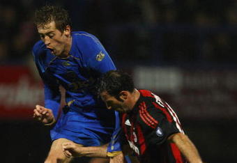 PORTSMOUTH, UNITED KINGDOM - NOVEMBER 27: Peter Crouch of Portsmouth clashes with Giuseppe Favalli of AC Milan during the UEFA Cup Group E match between Portsmouth and AC Milan at Fratton Park on November 27, 2008 in Portsmouth, England.  (Photo by Paul Gilham/Getty Images)