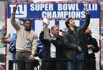 NEW YORK - FEBRUARY 05:  (L-R) Michael Strahan, Owner John Mara and Eli Manning of the New York Giants ride in a float along Broadway, also known as 'The Canyon of Heroes' during Super Bowl XLII victory parade in New York City.  (Photo by Al Bello/Getty Images)