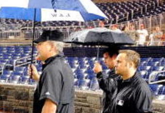 WASHINGTON - JUNE 03:  Assistant General Manager Mike Rizzo of the Washington Nationals talks with Jeff Kellogg and the umpire crew during a rain delay of the game between the San Francisco Giants and the Washington Nationals at Nationals Park on June 3, 2009 in Washington, DC.  (Photo by Greg Fiume/Getty Images)