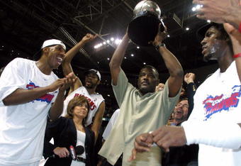 AUBURN HILLS, MI - JUNE 1:  (L-R) Chauncey Billups #1, Rasheed Wallace #30, President of Basketball Operations Joe Dumars (holding trophy) and Ben Wallace #3 of the Detroit Pistons celebrate their win over the Indiana Pacers in Game six of the Eastern Conference Finals during the 2004 NBA Playoffs at The Palace of Auburn Hills on June 1, 2004 in Auburn Hills, Michigan.  The Pistons defeated the Pacers 69-65 and won the 2004 Eastern Conference Championship.  NOTE TO USER: User expressly acknowledges and agrees that, by downloading and/or using this Photograph, user is consenting to the terms and conditions of the Getty Images License Agreement. (Photo by Tom Pidgeon/Getty Images)