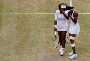 WIMBLEDON, ENGLAND - JULY 03:  Serena Williams of USA (L) and sister Venus Williams of USA talk tactics during the women's doubles semi final match against Cara Black of Zimbabwe and Liezel Huber of USA on Day Eleven of the Wimbledon Lawn Tennis Championships at the All England Lawn Tennis and Croquet Club on July 3, 2009 in London, England.  (Photo by Paul Gilham/Getty Images)