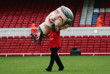 LONDON - MAY 07:  Member of the Arsenal groundstaff carries an Arsene Wenger papier mache head after the Barclays Premiership match between Arsenal and Wigan Athletic at Highbury on May 7, 2006 in London, England.  The match was the last to be played at Highbury after 93 years, as next season Arsenal will kick off nearby at the new Emirates Stadium.  (Photo by Shaun Botterill/Getty Images)