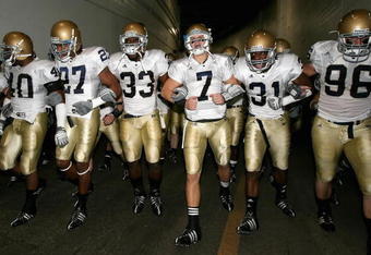 LOS ANGELES, CA - NOVEMBER 29:  Quarterback Jimmy Clausen #7 of the Notre Dame Fighting Irish walks out with teammates Robert Hughes #33 and Sergio Brown #31 before the game against the USC Trojans at Los Angeles Memorial Coliseum on November 29, 2008 in Los Angeles, California. The Trojans defeated the Fighting Irish 38-3.  (Photo by Christian Petersen/Getty Images)