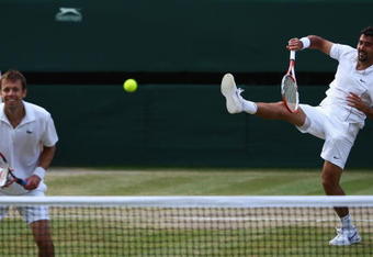 WIMBLEDON, ENGLAND - JULY 04:  Nenad Zimonjic of Serbia plays a smash playing with Daniel Nestor of Canada during the men's doubles final match against Bob Bryan of USA and Mike Bryan of USA on Day Twelve of the Wimbledon Lawn Tennis Championships at the All England Lawn Tennis and Croquet Club on July 4, 2009 in London, England.  (Photo by Clive Brunskill/Getty Images)