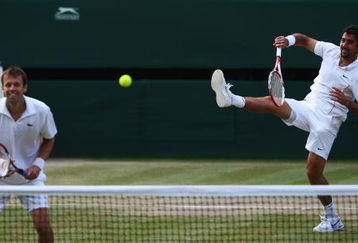 WIMBLEDON, ENGLAND - JULY 04:  Nenad Zimonjic of Serbia plays a smash playing with Daniel Nestor of Canada during the men's doubles final match against Bob Bryan of USA and Mike Bryan of USA on Day Twelve of the Wimbledon Lawn Tennis Championships at the All England Lawn Tennis and Croquet Club on July 4, 2009 in London, England.  (Photo by Clive Brunskill/Getty Images)
