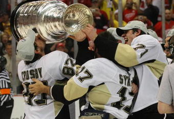 DETROIT - JUNE 12: (L-R) Sidney Crosby #87, Petr Sykora and Evgeni Malkin #71 of the Pittsburgh Penguins celebrate with the Stanley Cup following the Penguins victory over the Detroit Red Wings in Game Seven of the 2009 NHL Stanley Cup Finals at Joe Louis Arena on June 12, 2009 in Detroit, Michigan. (Photo by Bruce Bennett/Getty Images)