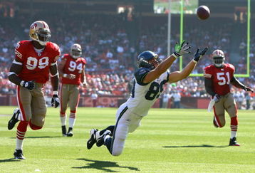 SAN FRANCISCO - OCTOBER 26:  Tight end John Carlson #89 of the Seattle Seahawks lunges but can't make a catch in front of Manny Lawson #99 of the San Francisco 49ers in the first quarter at Candlestick Park on October 26, 2008 in San Francisco, California. The Seahawks defeated the 49ers 34-13.  (Photo by Jeff Gross/Getty Images)