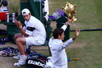 WIMBLEDON, ENGLAND - JULY 05:  Andy Roddick of USA looks despondent as Roger Federer of Switzerland celebrates with the trophy during the men's singles final match on Day Thirteen of the Wimbledon Lawn Tennis Championships at the All England Lawn Tennis and Croquet Club on July 5, 2009 in London, England. Federer won 5-7, 7-6, 7-6, 3-6, 16-14.  (Photo by Julian Finney/Getty Images)