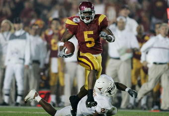 PASADENA, CA - JANUARY 04:  Running back Reggie Bush #5 of the USC Trojans carries the football past Aaron Harris #2 of the Texas Longhorns before fumbling the ball on the play in the second quarter during the BCS National Championship Rose Bowl Game on January 4, 2006 in Pasadena, California.  (Photo by Donald Miralle/Getty Images)
