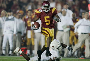 PASADENA, CA - JANUARY 04:  Running back Reggie Bush #5 of the USC Trojans carries the football past Aaron Harris #2 of the Texas Longhorns before fumbling the ball on the play in the second quarter during the BCS National Championship Rose Bowl Game on January 4, 2006 in Pasadena, California.  (Photo by Donald Miralle/Getty Images)