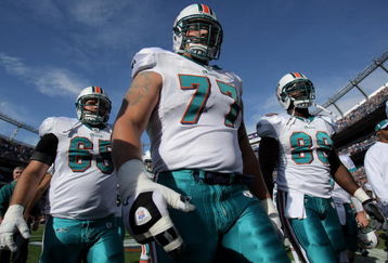 DENVER - NOVEMBER 02:  Guard Justin Smiley #65, tackle Jake Long #77 and tight end David Martin #88 of the Miami Dolphins leave the field after warming up prior to facing the Denver Broncos during NFL action at Invesco Field at Mile High on November 2, 2008 in Denver, Colorado. The Dolphins defeated the Broncos 26-17.  (Photo by Doug Pensinger/Getty Images)