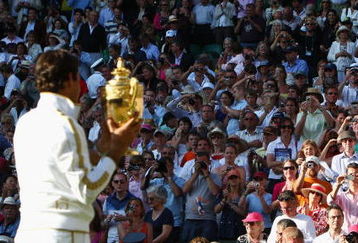 WIMBLEDON, ENGLAND - JULY 05:  Roger Federer of Switzerland celebrates victory with the trophy after the men's singles final match against Andy Roddick of USA on Day Thirteen of the Wimbledon Lawn Tennis Championships at the All England Lawn Tennis and Croquet Club on July 5, 2009 in London, England. Federer won 5-7, 7-6, 7-6, 3-6, 16-14.  (Photo by Clive Brunskill/Getty Images)