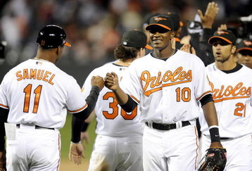 BALTIMORE - APRIL 06:  Adam Jones #10 of the Baltimore Orioles celebrates with Juan Samuel #11 after a 10-5 victory against the New York Yankees during opening day on April 6, 2009 at Camden Yards in Baltimore, Maryland.  (Photo by Greg Fiume/Getty Images)