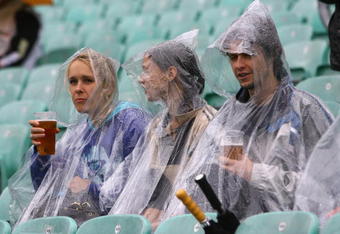 LONDON, ENGLAND - JUNE 06:  Fans take cover from the rain before the ICC Twenty20 World Cup match between New Zealand and Scotland at The Brit Oval on June 6, 2009 in London, England.  (Photo by Tom Shaw/Getty Images)
