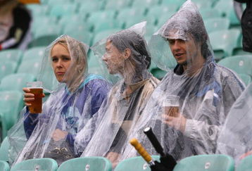 LONDON, ENGLAND - JUNE 06:  Fans take cover from the rain before the ICC Twenty20 World Cup match between New Zealand and Scotland at The Brit Oval on June 6, 2009 in London, England.  (Photo by Tom Shaw/Getty Images)