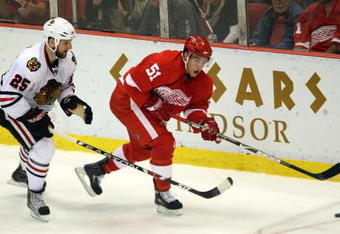 DETROIT - MAY 27:  Valtteri Filppula #51 of the Detroit Red Wings passes the puck against Cam Barker #25 of the Chicago Blackhawks during Game Five of the Western Conference Championship Round of the 2009 Stanley Cup Playoffs on May 27, 2009 at Joe Louis Arena in Detroit, Michigan. The Red Wings won 2-1 in overtime. (Photo by Claus Andersen/Getty Images)