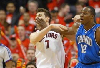 TORONTO,ON - APRIL 24:  Andrea Bargnani #7 of the Toronto Raptors takes a shot in the face from Dwight Howard #12 of the Orlando Magic in Game 3 of the Eastern Conference Quarterfinals on April 24, 2008 at the Air Canada Centre in Toronto, Ontario. The Raptors defeated the Magic 108-94. (Photo by Claus Andersen/Getty Images)