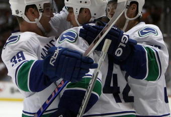 ANAHEIM, CA - SEPTEMBER 28:  Kyle Wellwood #42 of the Vancouver Canucks is congratulated by teammates Cody Hodgson #39 and Lawrence Nycholat #32 after Wellwood scored a second period goal against the Anaheim Ducks during the preseason NHL game at Honda Center on September 28, 2008 in Anaheim, California.  (Photo by Christian Petersen/Getty Images)