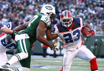 EAST RUTHERFORD, NJ - DECEMBER 14:  Marshawn Lynch #23 of the Buffalo Bills attempts to elude the tackle of Calvin Pace #97 of the New York Jets during their game on December 14, 2008 at Giants Stadium in East Rutherford, New Jersey.  (Photo by Al Bello/Getty Images)