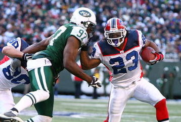 EAST RUTHERFORD, NJ - DECEMBER 14:  Marshawn Lynch #23 of the Buffalo Bills attempts to elude the tackle of Calvin Pace #97 of the New York Jets during their game on December 14, 2008 at Giants Stadium in East Rutherford, New Jersey.  (Photo by Al Bello/Getty Images)