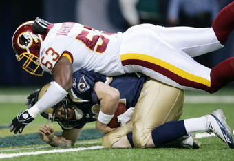 ST. LOUIS - DECEMBER 4:  Marcus Washington #53 of the Washington Redskins sacks Ryan Fitzpatrick #12 of the St. Louis Rams on December 4, 2005 at the Edward Jones Dome in St. Louis, Missouri.  (Photo by Elsa/Getty Images)