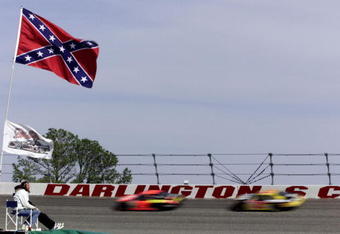 18 Mar 2001: Beneath the old Confederate States flag the the 'stars and bars'' a fan watches the racers flash past the wall during the NASCAR Winston Cup Carolina Dodge Dealers 400 at the Darlington Raceway, Darlington, South Carolina. Mandatory Credit: Donald Miralle/ALLSPORT