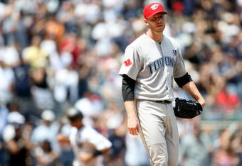 NEW YORK - JULY 04:  Roy Halladay #32 of the Toronto Blue Jays reacts after Jorge Posada #20 of the New York Yankees hit a home run in the fourth inning on July 4, 2009 at Yankee Stadium in the Bronx borough of New York City.  (Photo by Nick Laham/Getty Images)