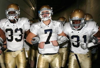 LOS ANGELES, CA - NOVEMBER 29:  Quarterback Jimmy Clausen #7 of the Notre Dame Fighting Irish walks out with teammates Robert Hughes #33 and Sergio Brown #31 before the game against the USC Trojans at Los Angeles Memorial Coliseum on November 29, 2008 in Los Angeles, California. The Trojans defeated the Fighting Irish 38-3.  (Photo by Christian Petersen/Getty Images)
