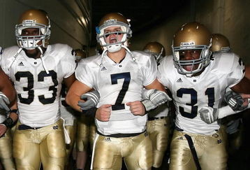 LOS ANGELES, CA - NOVEMBER 29:  Quarterback Jimmy Clausen #7 of the Notre Dame Fighting Irish walks out with teammates Robert Hughes #33 and Sergio Brown #31 before the game against the USC Trojans at Los Angeles Memorial Coliseum on November 29, 2008 in Los Angeles, California. The Trojans defeated the Fighting Irish 38-3.  (Photo by Christian Petersen/Getty Images)