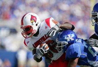 LEXINGTON, KY - SEPTEMBER 4:  Wide receiver Montrell Jones #86 of the University of Louisville Cardinals is tackled by cornerback Bo Smith #24 of the University of Kentucky Wildcats on September 4, 2005 at Commonwealth Stadium in Lexington, Kentucky.  The Cardinals won 31-24.  (Photo by Andy Lyons/Getty Images)