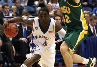 MINNEAPOLIS - MARCH 20:  Sherron Collins #4 of the Kansas Jayhawks drives the ball in the second half against Josh Vaughn #32 of the North Dakota State Bison during the first round of the NCAA Division I Men's Basketball Tournament at the Hubert H. Humphrey Metrodome on March 20, 2009 in Minneapolis, Minnesota.  (Photo by Jonathan Daniel/Getty Images)