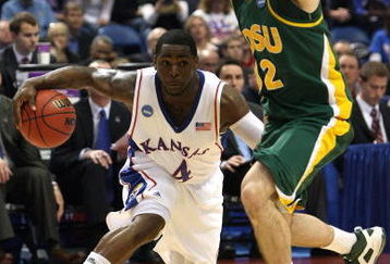 MINNEAPOLIS - MARCH 20:  Sherron Collins #4 of the Kansas Jayhawks drives the ball in the second half against Josh Vaughn #32 of the North Dakota State Bison during the first round of the NCAA Division I Men's Basketball Tournament at the Hubert H. Humphrey Metrodome on March 20, 2009 in Minneapolis, Minnesota.  (Photo by Jonathan Daniel/Getty Images)