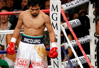 LAS VEGAS - MAY 02:  Manny Pacquiao of the Philippines looks down at referee Kenny Bayless counting after Ricky Hatton of England was knocked down in the first round during their junior welterweight title fight at the MGM Grand Garden Arena May 2, 2009 in Las Vegas, Nevada.  (Photo by Ethan Miller/Getty Images)