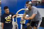 VANCOUVER - SEPTEMBER 14:  Jason Lee looks on as goaltender Roberto Luongo of the Vancouver Canucks rides an exercise bike as he does his VO2 training during veterans' day at the Vancouver Canucks training camp at General Motors Place on September 14, 2006 in Vancouver, Canada.   (Photo by Jeff Vinnick/Getty Images)