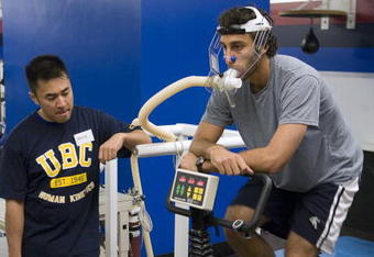 VANCOUVER - SEPTEMBER 14:  Jason Lee looks on as goaltender Roberto Luongo of the Vancouver Canucks rides an exercise bike as he does his VO2 training during veterans' day at the Vancouver Canucks training camp at General Motors Place on September 14, 2006 in Vancouver, Canada.   (Photo by Jeff Vinnick/Getty Images)