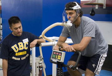 VANCOUVER - SEPTEMBER 14:  Jason Lee looks on as goaltender Roberto Luongo of the Vancouver Canucks rides an exercise bike as he does his VO2 training during veterans' day at the Vancouver Canucks training camp at General Motors Place on September 14, 2006 in Vancouver, Canada.   (Photo by Jeff Vinnick/Getty Images)