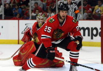 CHICAGO - MAY 24:  Cam Barker #25 of the Chicago Blackhawks defends against the Detroit Red Wings during Game Four of the Western Conference Championship Round of the 2009 Stanley Cup Playoffs on May 24, 2009 at the United Center in Chicago, Illinois. The Red Wings won 6-1. (Photo by Jonathan Daniel/Getty Images)