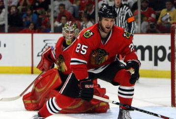 CHICAGO - MAY 24:  Cam Barker #25 of the Chicago Blackhawks defends against the Detroit Red Wings during Game Four of the Western Conference Championship Round of the 2009 Stanley Cup Playoffs on May 24, 2009 at the United Center in Chicago, Illinois. The Red Wings won 6-1. (Photo by Jonathan Daniel/Getty Images)