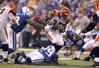 INDIANAPOLIS - DECEMBER 07:  Cedric Benson #32 of the Cincinnati Bengals runs the ball against Bob Sanders #21 and Raheem Brock #79 of the Indianapolis Colts at Lucas Oil Stadium on December 7, 2008 in Indianapolis, Indiana.  (Photo by Andy Lyons/Getty Images)