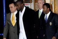 NEW YORK - DECEMBER 1:  Wide receiver Plaxico Burress (2L) of the New York Giants is led to a squad car for transport to his arraignment outside the NYPD 17th Precinct December 1, 2008 in New York City. Burress, who is expected to face a charge of criminal possession of a weapon, was released from the hospital yesterday after accidentally shooting himself in the right thigh at a nightclub in Manhattan on the night of November 28.  (Photo by Jeff Zelevansky/Getty Images)