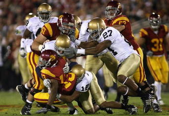 LOS ANGELES, CA - NOVEMBER 29:  Runningback Stafon Johnson #13 of the USC Trojans is tackled by the Notre Dame Fighting Irish during the game at Los Angeles Memorial Coliseum on November 29, 2008 in Los Angeles, California. The Trojans defeated the Fighting Irish 38-3.  (Photo by Christian Petersen/Getty Images)