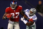 EAST RUTHERFORD, NJ - NOVEMBER 11:  Brandon Jacobs #27 of the New York Giants breaks the tackle of Bradie James #56 of the Dallas Cowboys during their game at Giants Stadium November 11, 2007 in East Rutherford, New Jersey. The Giants won 31-20.  (Photo by Al Bello/Getty Images)