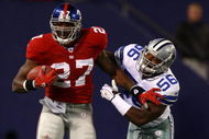 EAST RUTHERFORD, NJ - NOVEMBER 11:  Brandon Jacobs #27 of the New York Giants breaks the tackle of Bradie James #56 of the Dallas Cowboys during their game at Giants Stadium November 11, 2007 in East Rutherford, New Jersey. The Giants won 31-20.  (Photo by Al Bello/Getty Images)