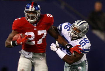 EAST RUTHERFORD, NJ - NOVEMBER 11:  Brandon Jacobs #27 of the New York Giants breaks the tackle of Bradie James #56 of the Dallas Cowboys during their game at Giants Stadium November 11, 2007 in East Rutherford, New Jersey. The Giants won 31-20.  (Photo by Al Bello/Getty Images)