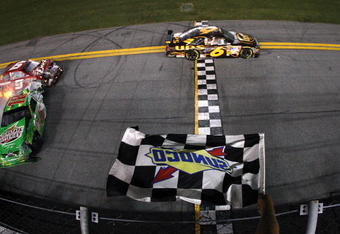 DAYTONA BEACH, FL - JULY 04:  Kyle Busch, driver of the Interstate Batteries Toyota, crashes into the wall on the final lap as he crosses the finish line and Kasey Kahne, driver of the #9 Budweiser Dodge, crashes into the back of him during the NASCAR Sprint Cup Series 51st Annual Coke Zero 400 at Daytona International Speedway on July 4, 2009 in Daytona Beach, Florida.  (Photo by Streeter Lecka/Getty Images)
