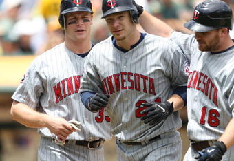 OAKLAND, CA - JUNE 11:  Joe Crede #24 of the Minnesota Twins is congratulated by Jason Kubel #16 and Justin Morneau #33 after hitting a home run in the fourth inning against the Oakland Athletics during a Major League Baseball game on June 11, 2009 at the Oakland Coliseum in Oakland, California.  (Photo by Jed Jacobsohn/Getty Images)