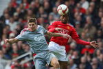 MANCHESTER, UNITED KINGDOM - MARCH 14:  Steven Gerrard of Liverpool goes up for a header with Patrice Evra of Manchester United during the Barclays Premier League match between Manchester United and Liverpool at Old Trafford on March 14, 2009 in Manchester, England. (Photo by Laurence Griffiths/Getty Images)
