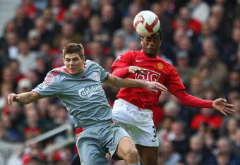 MANCHESTER, UNITED KINGDOM - MARCH 14:  Steven Gerrard of Liverpool goes up for a header with Patrice Evra of Manchester United during the Barclays Premier League match between Manchester United and Liverpool at Old Trafford on March 14, 2009 in Manchester, England. (Photo by Laurence Griffiths/Getty Images)