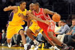 LOS ANGELES, CA - MAY 06:  Ron Artest #96 of the Houston Rockets moves the ball as Trevor Ariza #3 of the Los Angeles Lakers goes for the steal alongside teammate Lamar Odom #7 in Game Two of the Western Conference Semifinals during the 2009 NBA Playoffs at Staples Center on May 6, 2009 in Los Angeles, California. NOTE TO USER: User expressly acknowledges and agrees that, by downloading and or using this photograph, User is consenting to the terms and conditions of the Getty Images License Agreement.  (Photo by Harry How/Getty Images)