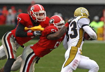 ATHENS, GA - NOVEMBER 29:  Linebacker Akeem Dent #51 and safety Andrew Willams #47 of the Georgia Bulldogs tackle wide receiver Andrew Smith #83 of the Georgia Tech Yellow Jackets while a penalty flag is thrown in the air during the game at Sanford Stadium on November 29, 2008 in Athens, Georgia.  The Yellow Jackets defeated the Bulldogs 45-42.  (Photo by Mike Zarrilli/Getty Images)